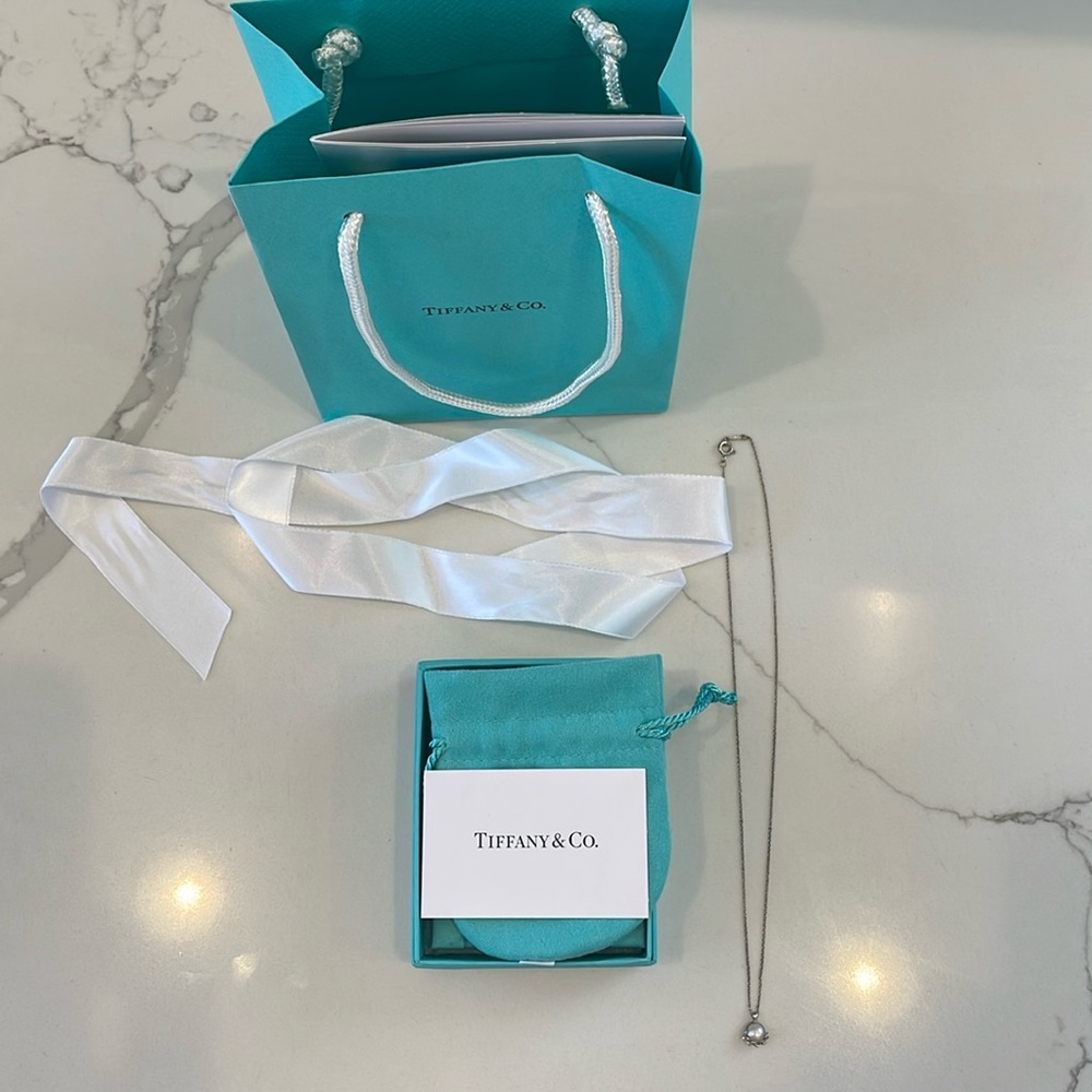 Beautiful Tiffany & Co. pearl necklace with original packaging and white ribbon.